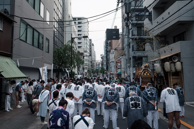 Every neighbourhood in Japan has a local guardian deity (ujigami) who looks after the community and their families. The Kanda Festival is a time when the deities are transported into portable shrines (mikoshi) and carried through the streets to bless the local residents. Here in Tokyo, the Hamacho community bows in the city streets as a Shinto priest leads them in the ritual’s final moments. After a long weekend of carrying and shaking the heavy shrine on their shoulders, it has found its resting place for the coming year.