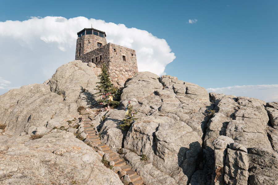 The stone fire lookout tower on the granite summit of Black Elk Peak, a staircase winding up the rock toward it